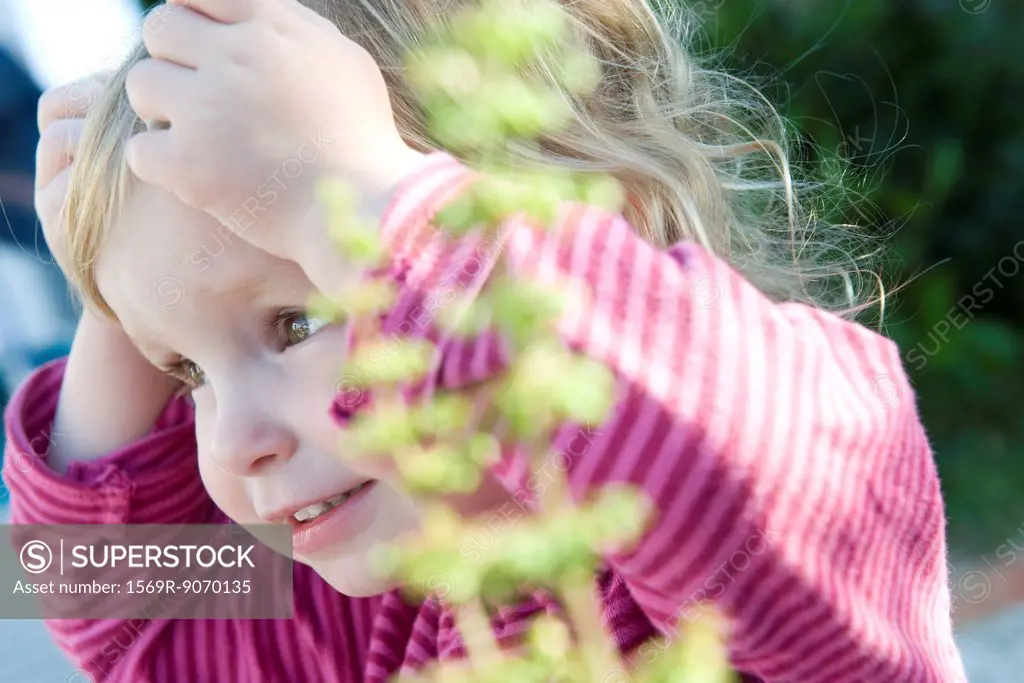 Toddler girl with surprised expression, hands on head
