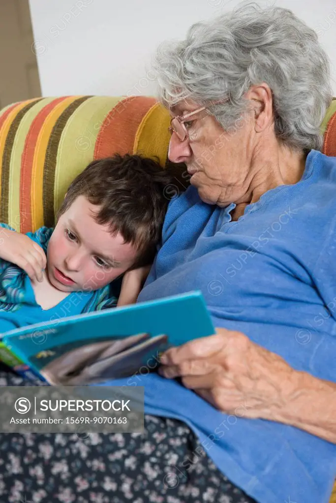 Grandmother and grandson reading book together