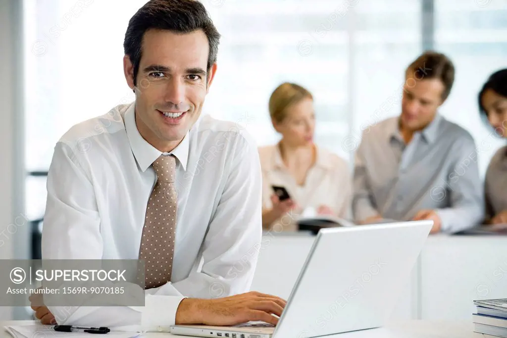 Smiling businessman using laptop computer