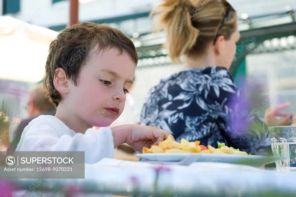 Boy eating in outdoor cafe