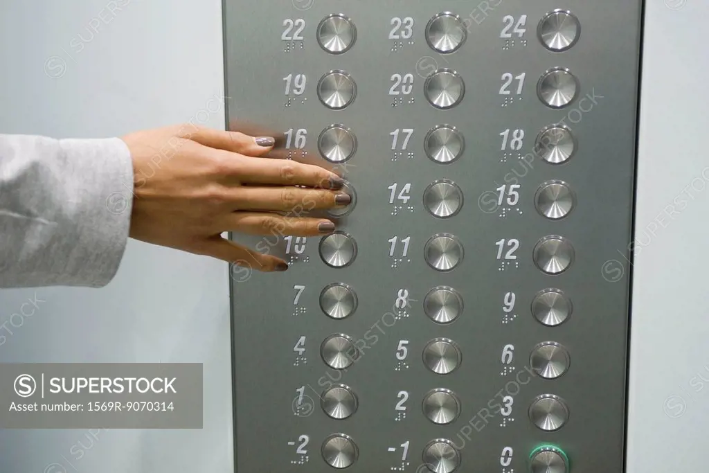 Woman´s hand pressing elevator button, cropped