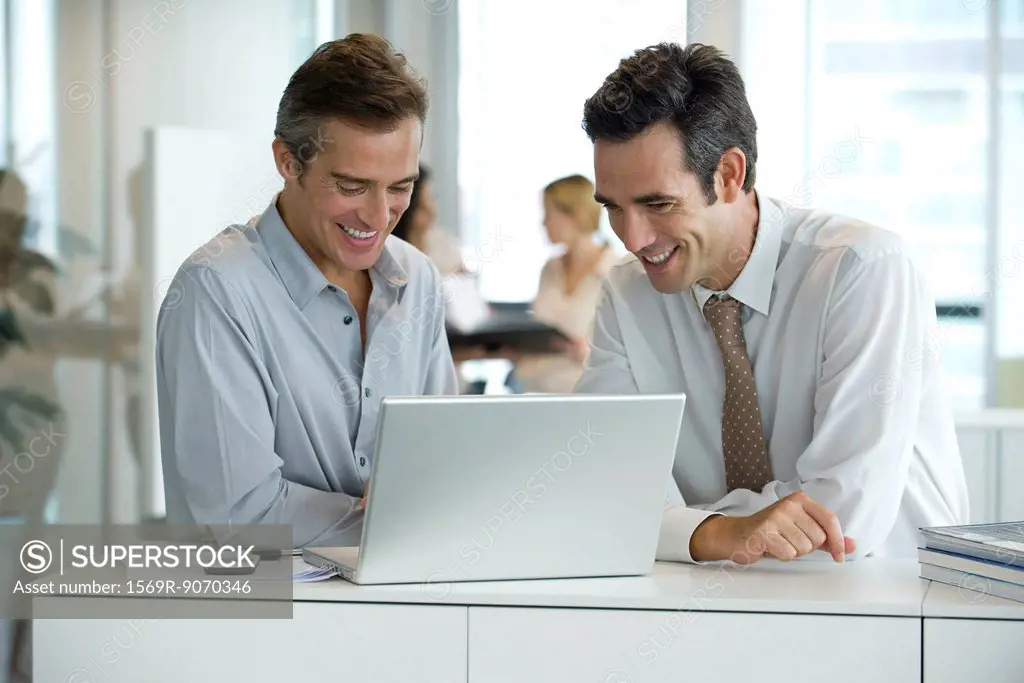 Executives working together on laptop computer