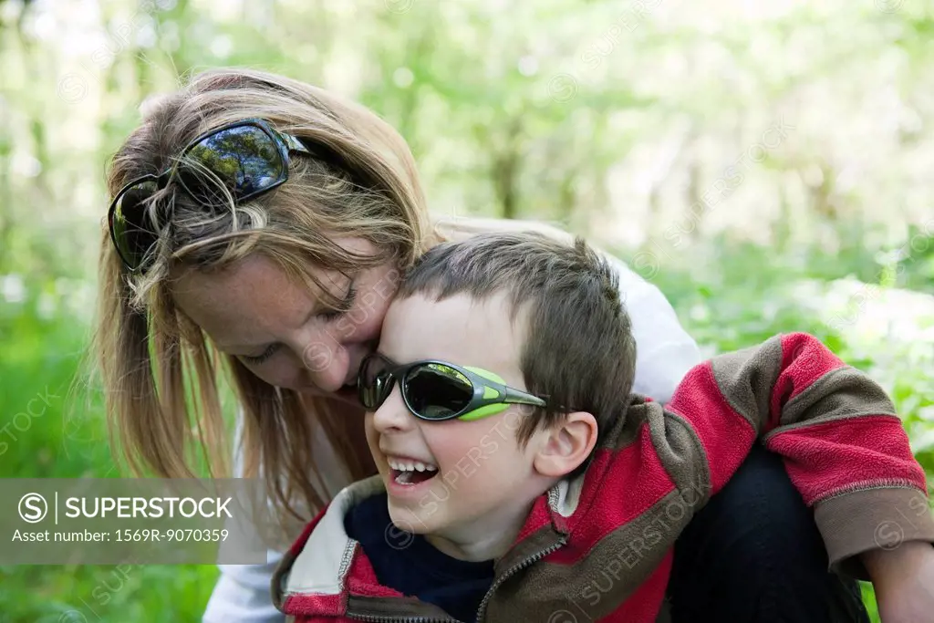 Mother and young son laughing together outdoors