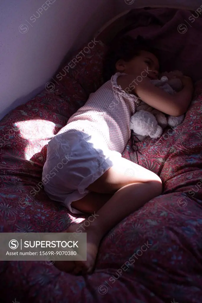 Little girl lying on bed