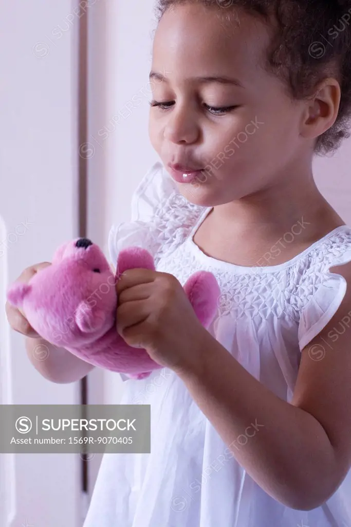 Little girl playing with teddy bear