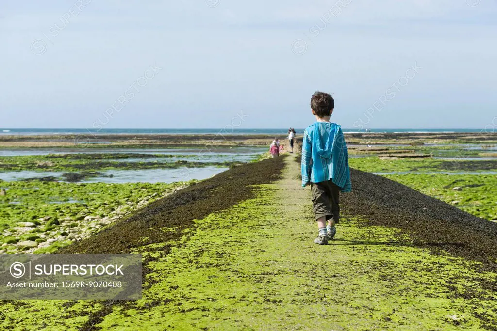 Boy walking on breakwater, Ile de Ré, Charente_Maritime, France