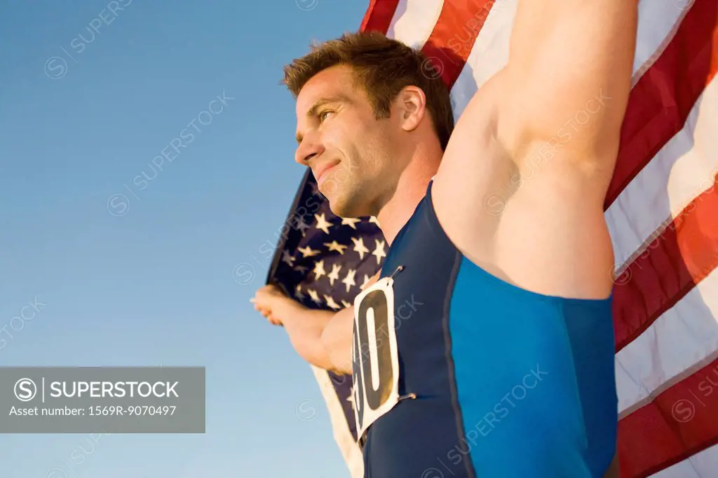 Athlete holding American flag, low angle view