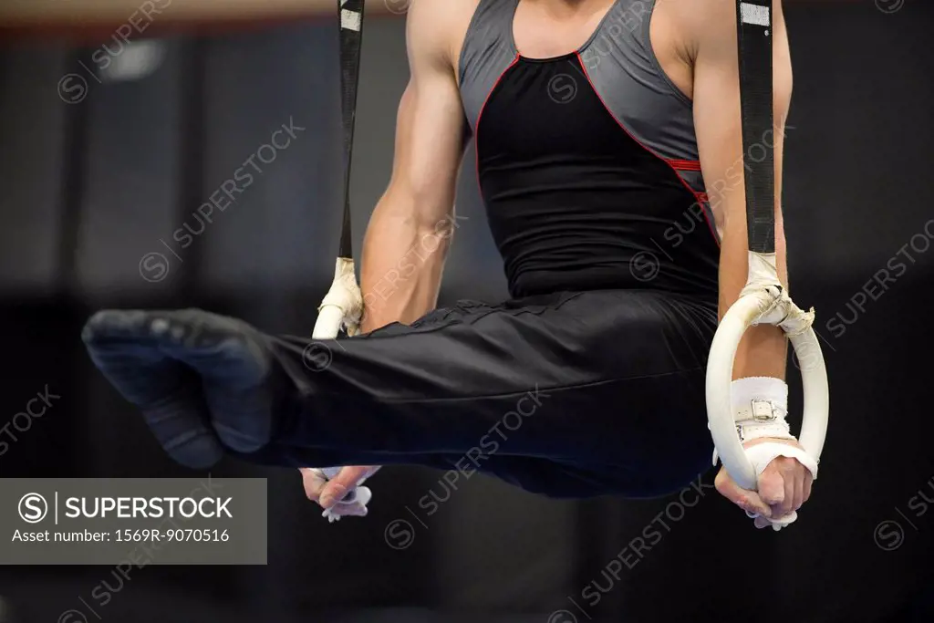 Male gymnast on the rings, cropped