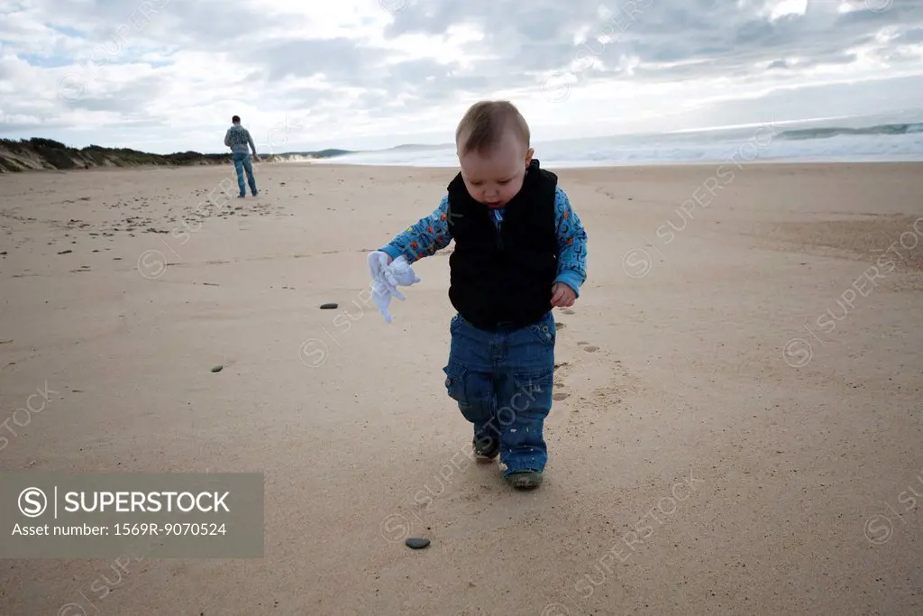 Toddler walking on beach