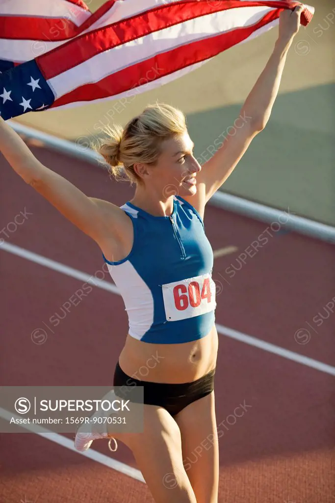 Woman running on track with American flag