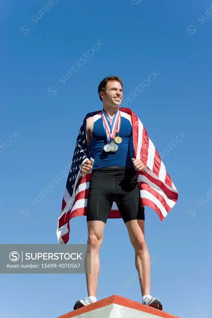 Male athlete on winner´s podium, wrapped in American flag