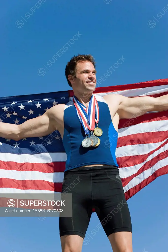 Male athlete on winner´s podium, holding up American flag