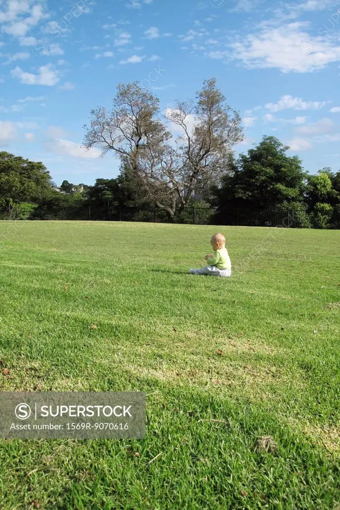 Baby sitting alone in field