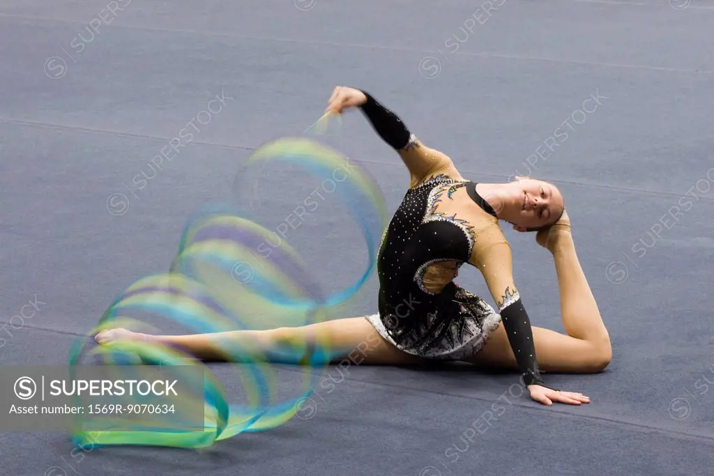 Female gymnast performing floor routine with ribbon