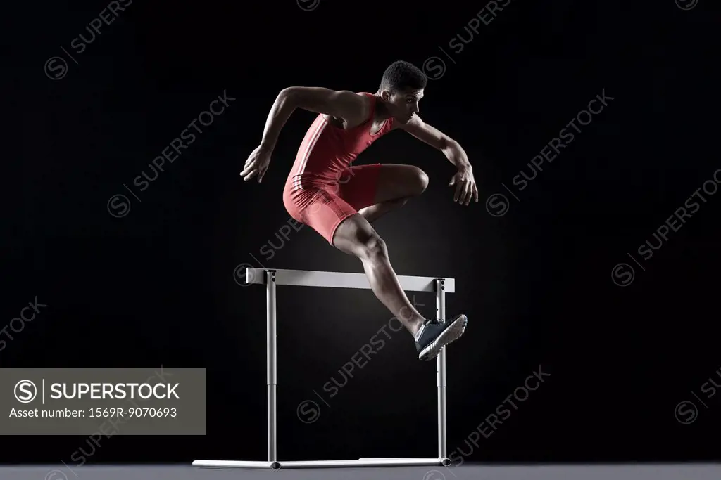 Male athlete cearling hurdle