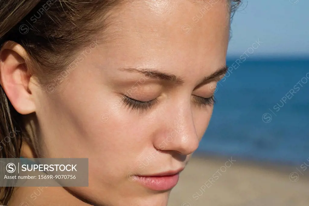 Woman at the beach with eyes closed, portrait