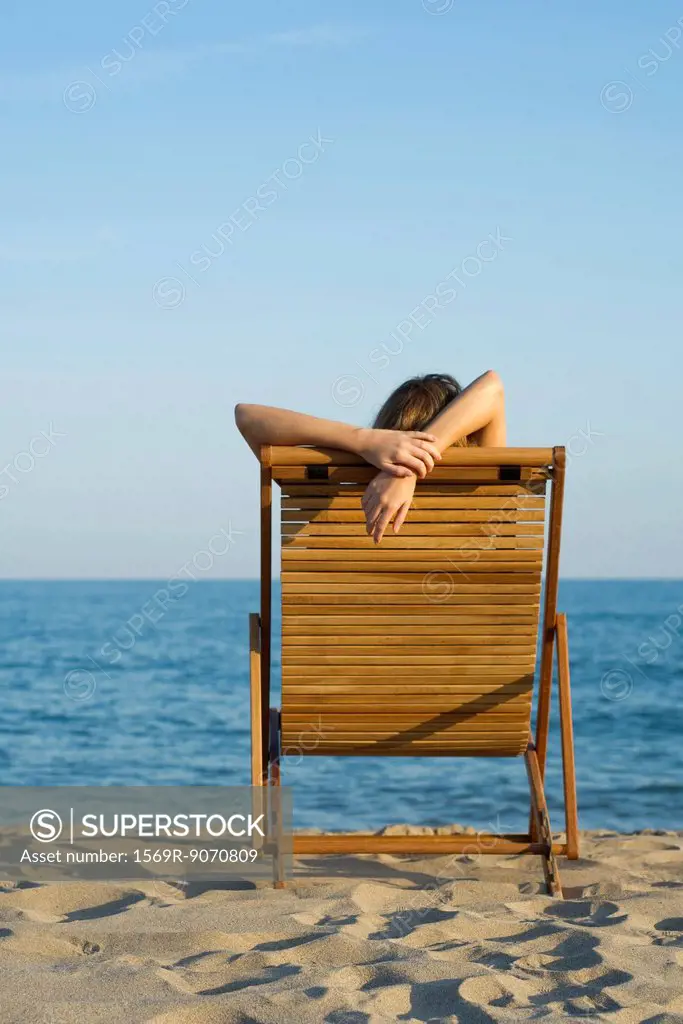 Woman relaxing in lounge chair on beach