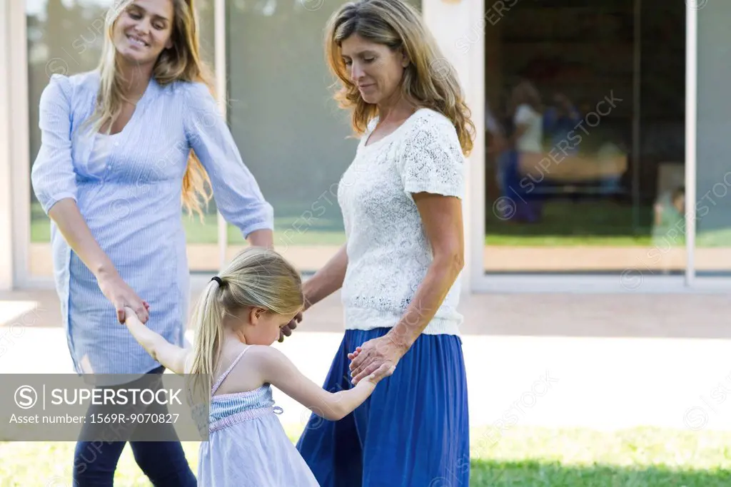 Grandmother, mother and daughter holding hands