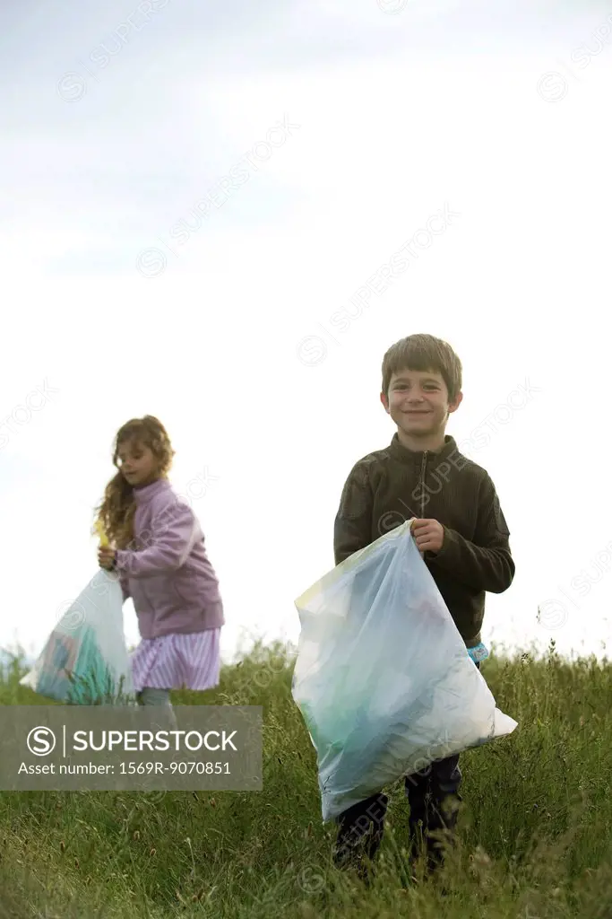 Children picking up trash in field