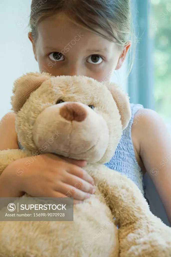 Little girl hugging teddy bear