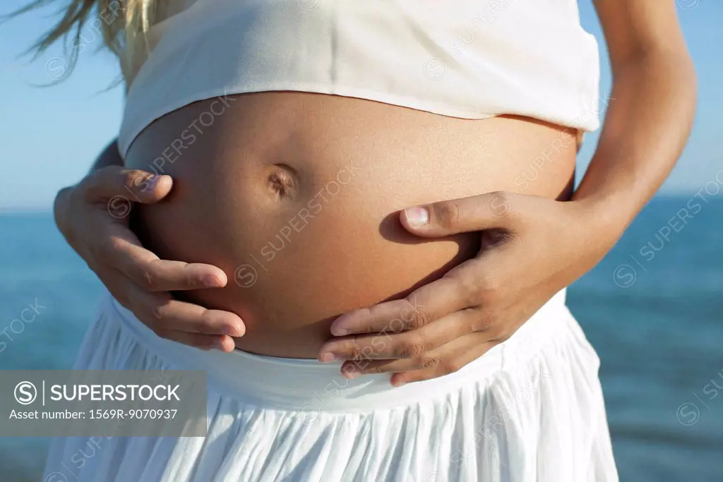 Woman´s hands on pregnant belly, cropped