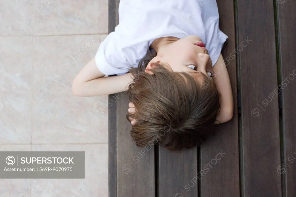 Boy lying on floor, looking away in thought