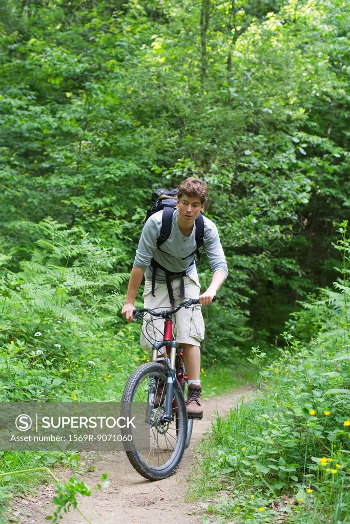 Man riding bicycle through woods