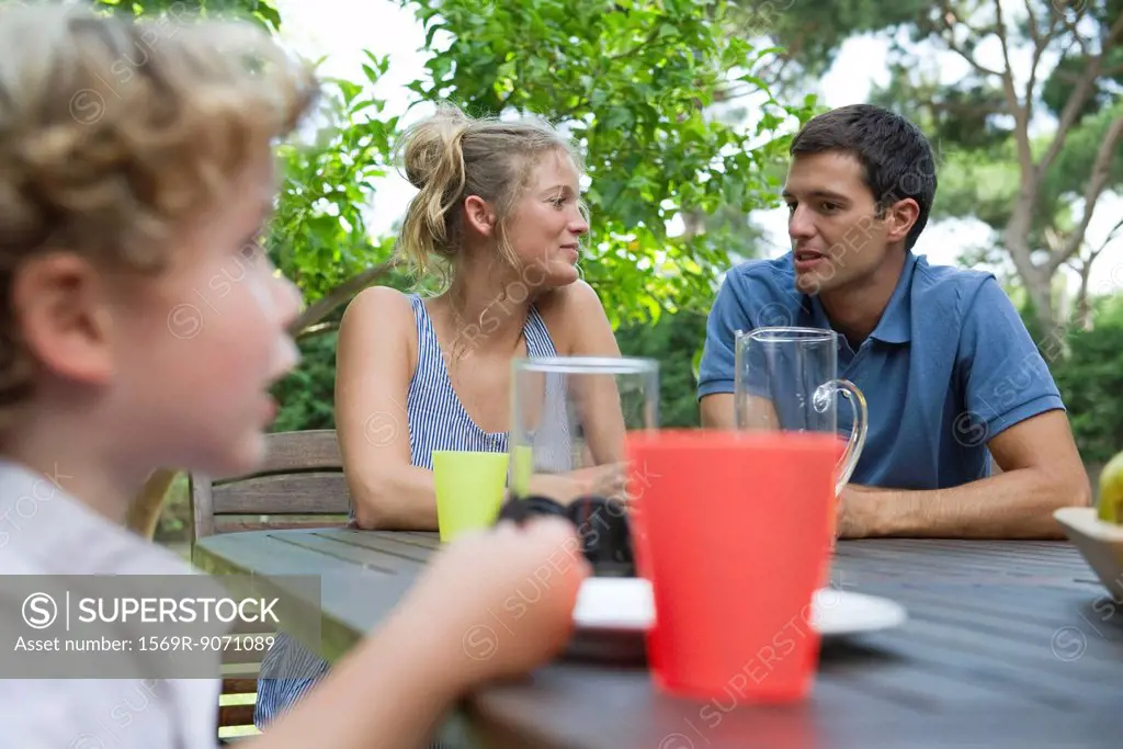 Family relaxing together at table outdoors