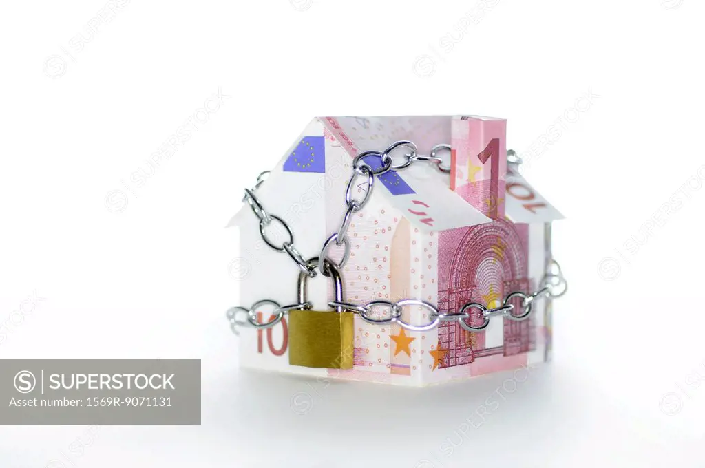 Model house folded with euro banknotes chained and padlocked