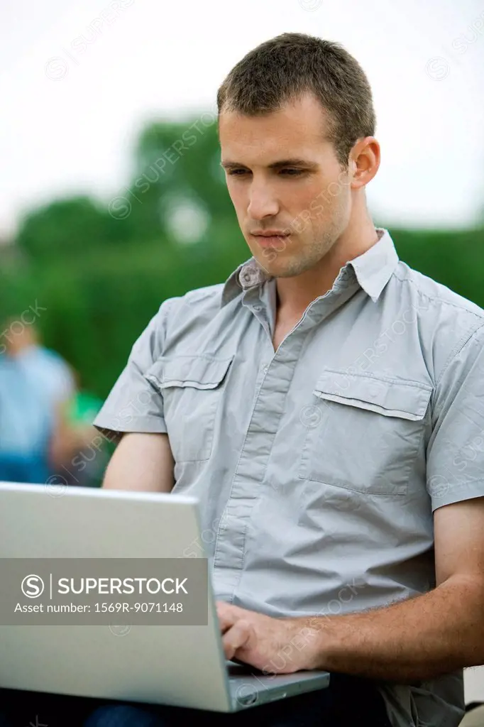 Man using laptop computer outdoors