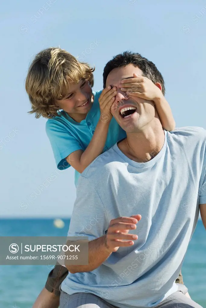 Boy covering father´s eyes with hands