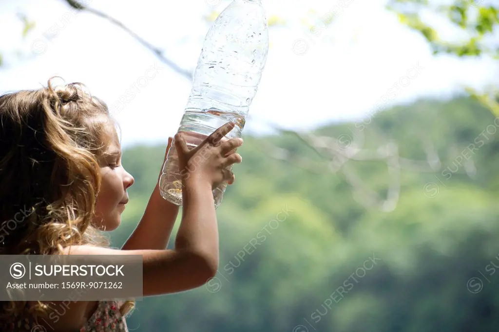 Girl looking at fish in water bottle