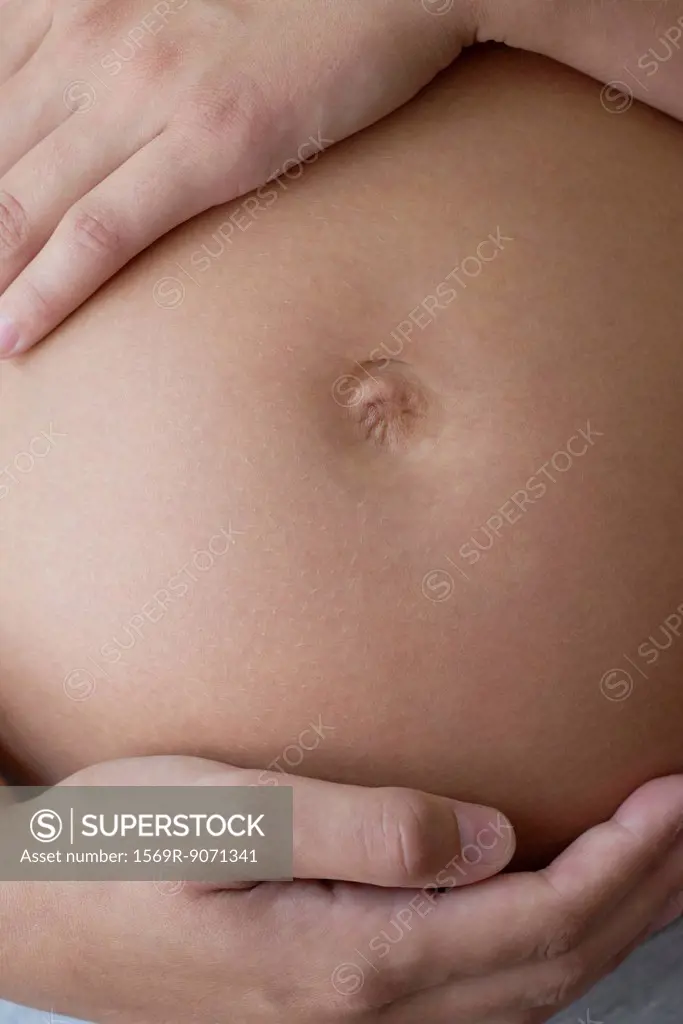 Pregnant woman touching her belly, cropped