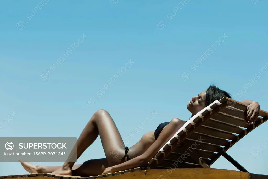 Woman relaxing on deckchair in sun