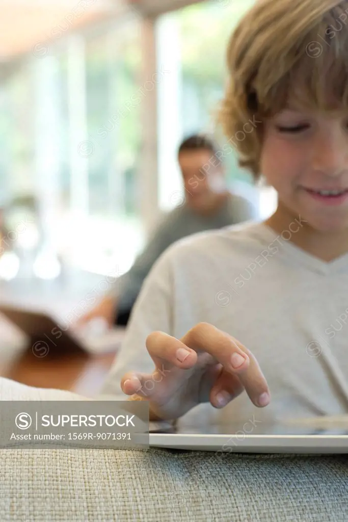 Boy using digital tablet, focus on hand