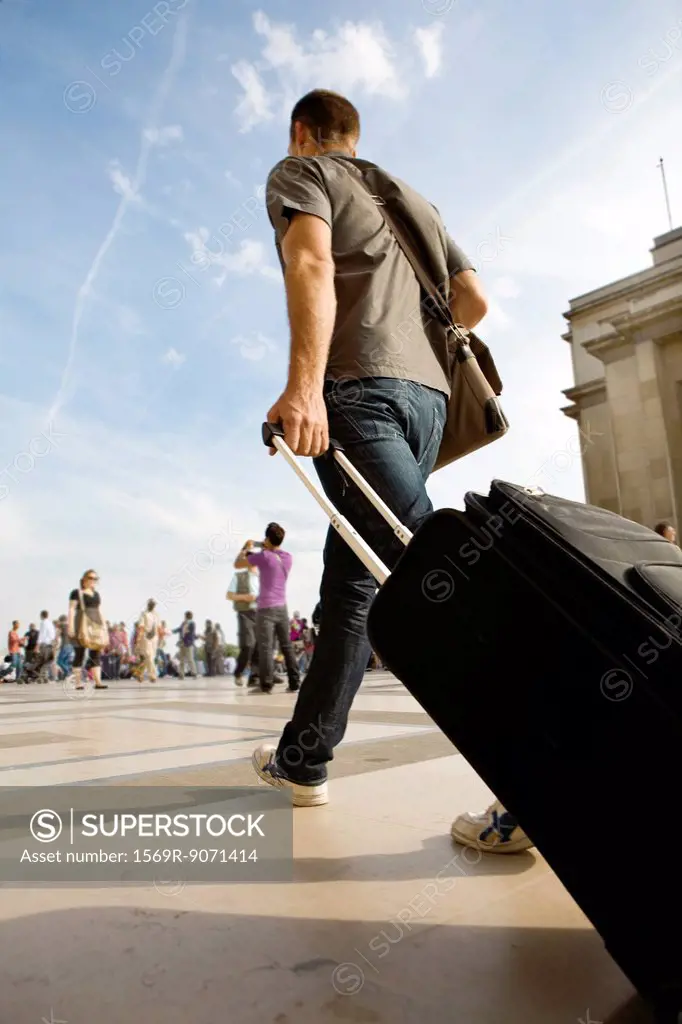 Man walking with rolling luggage