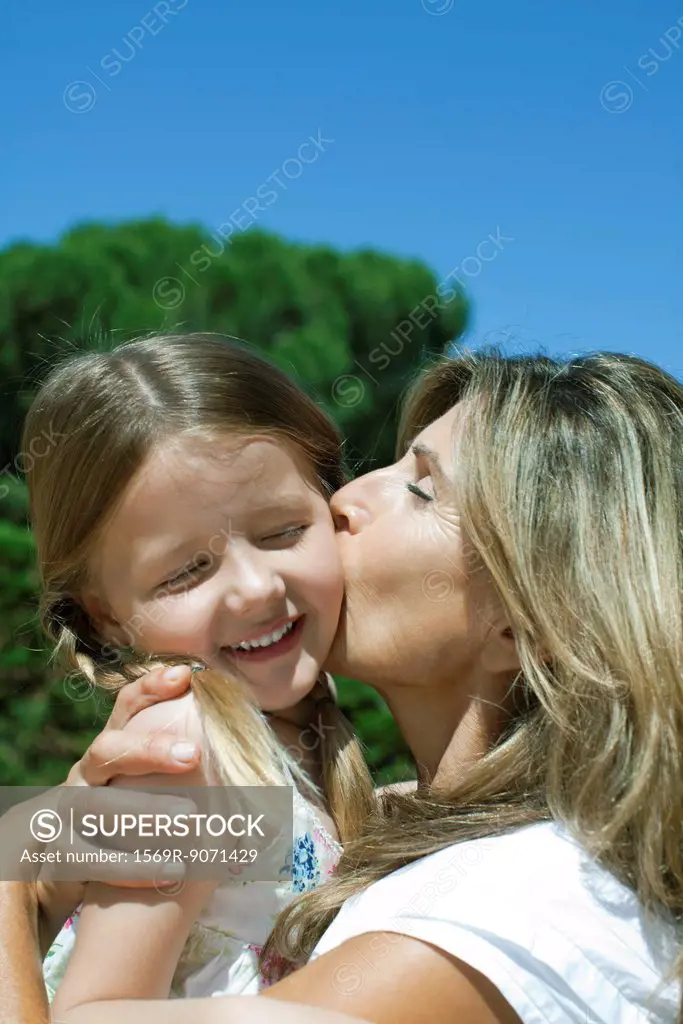 Mother kissing daughter´s cheek