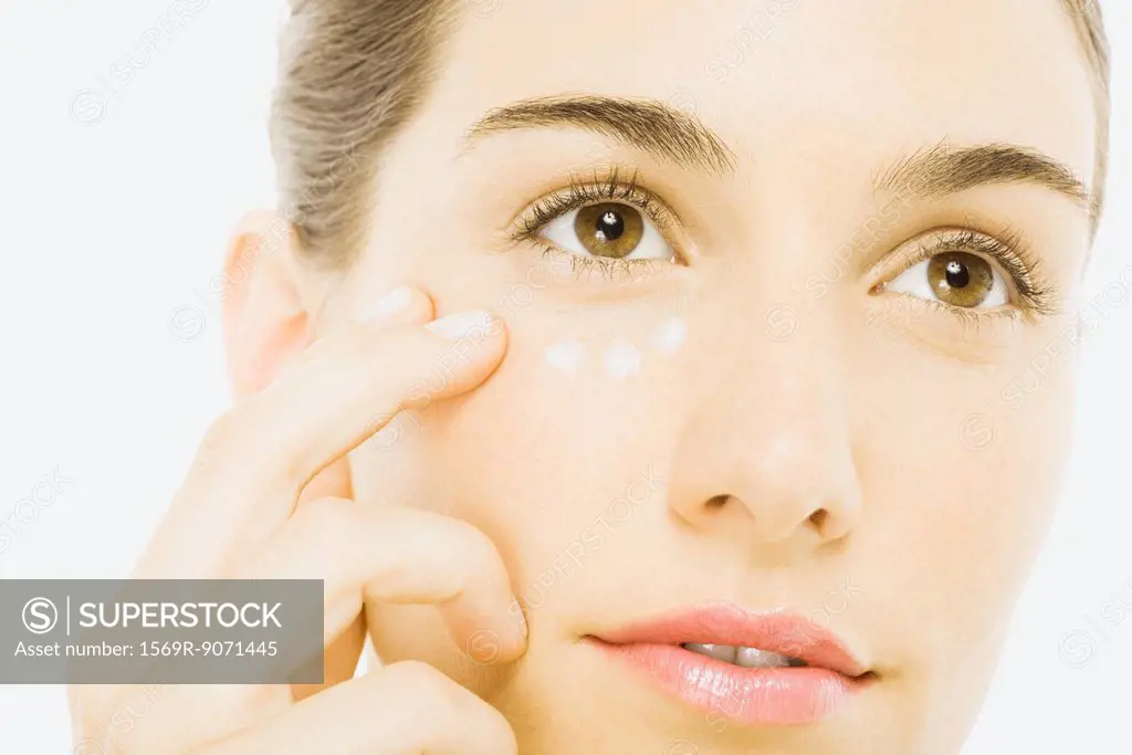 Woman applying undereye cream, close_up