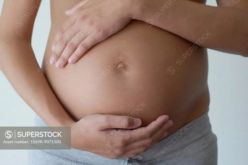 Pregnant woman holding her belly, cropped