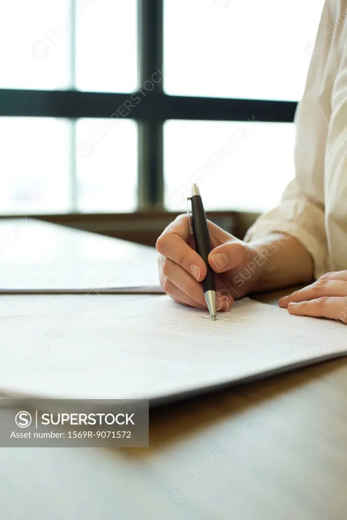 Person signing contract, cropped