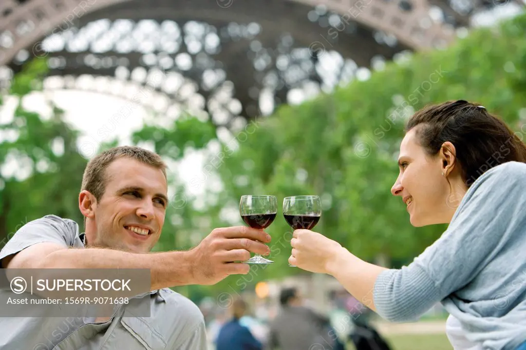 Couple clinking wine glasses outdoors