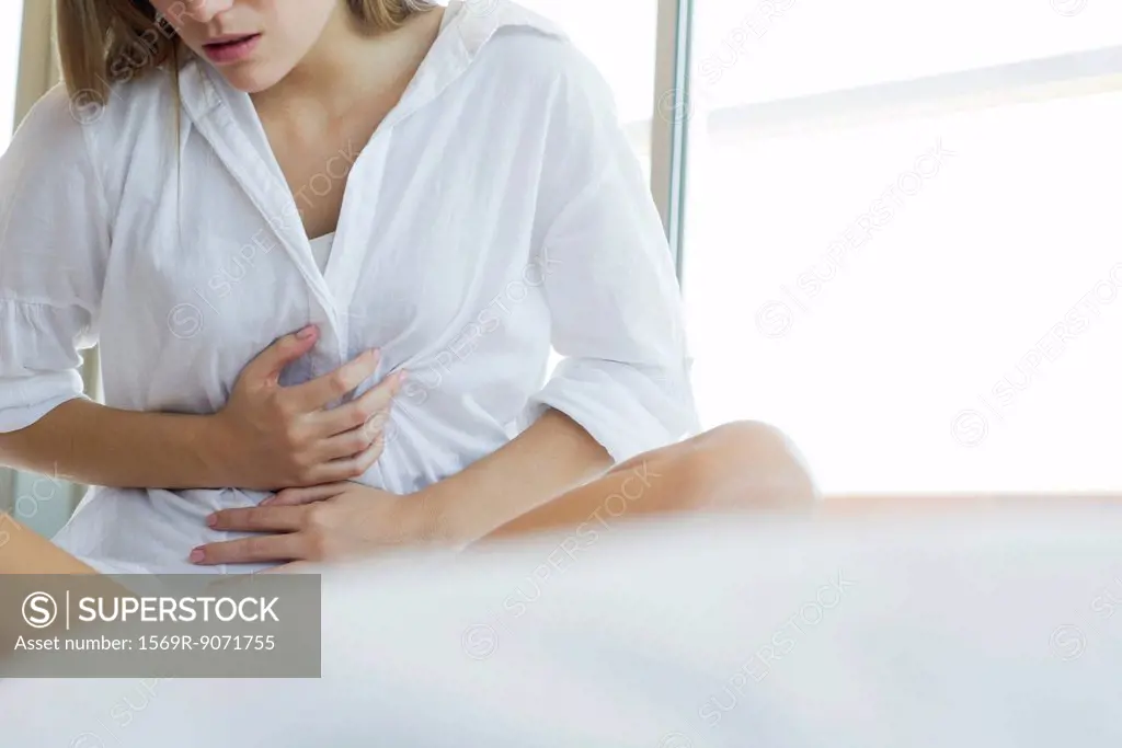 Woman experiencing abdominal pain, cropped