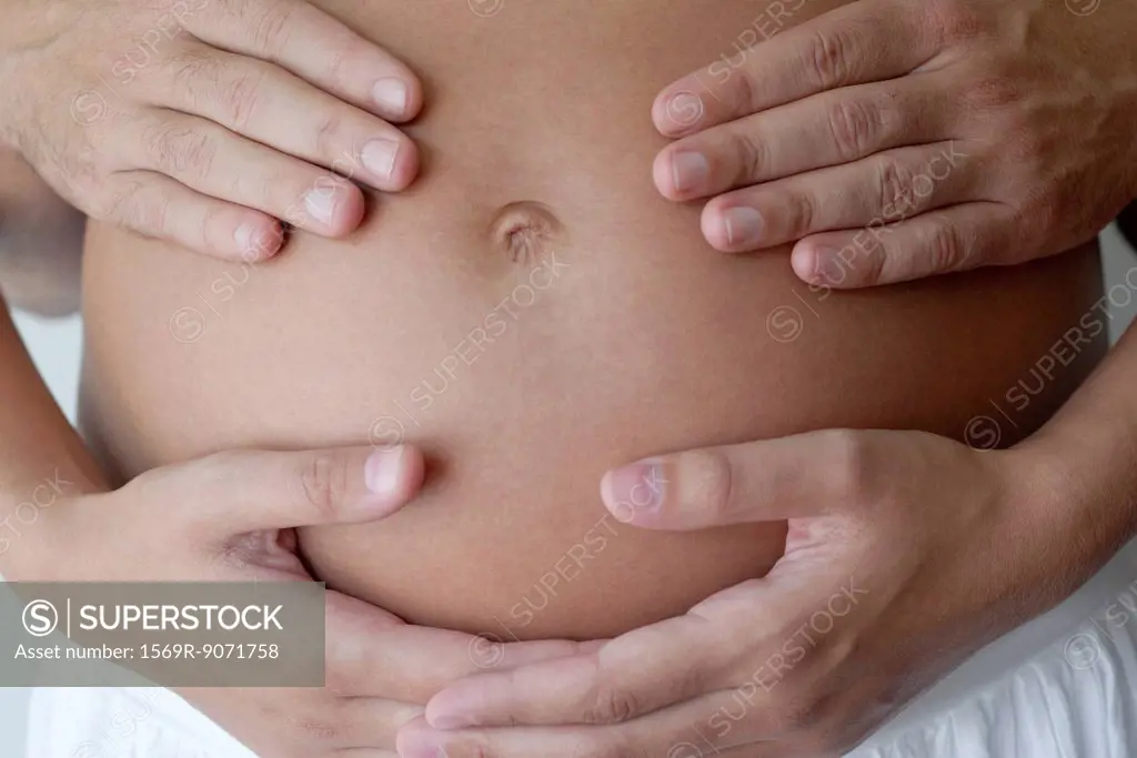 Couple´s hands on woman´s pregnant belly