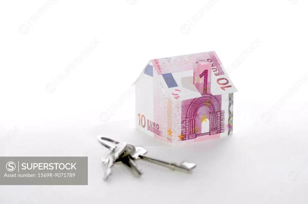 Model house folded with euro banknotes and keys