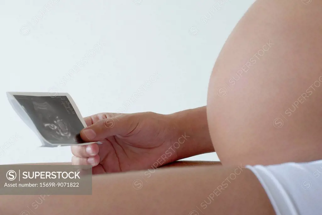 Pregnant woman looking at ultrasound, cropped
