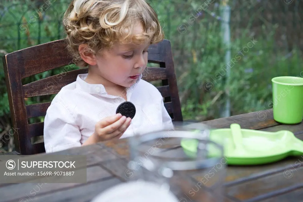 Boy eating cookie outdoors