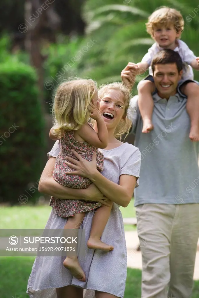 Parents carrying children outdoors