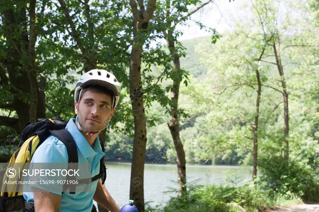 Man wearing cycling helmet in woods