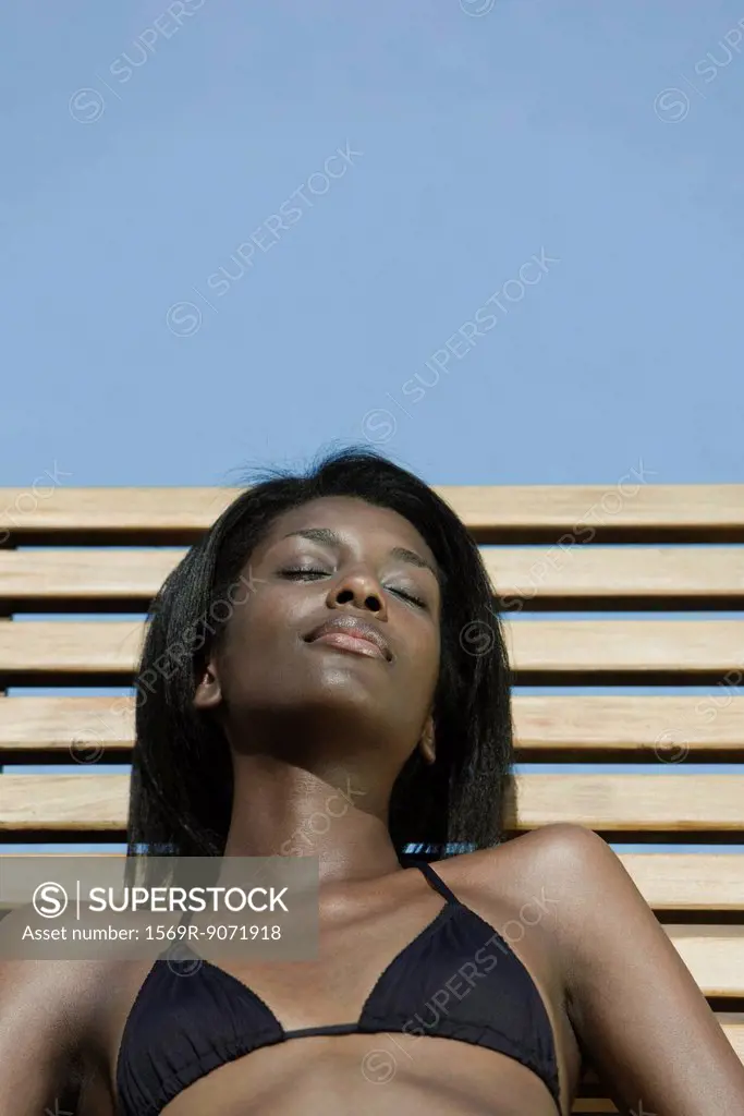 Woman reclining on deckchair, sunbathing
