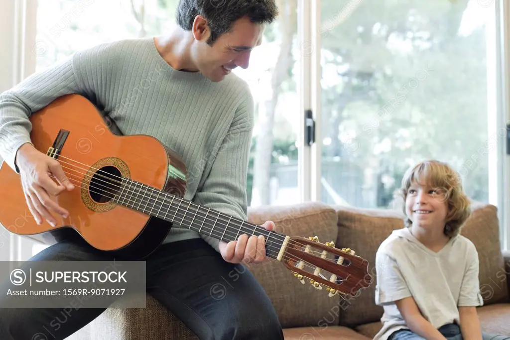 Father playing guitar for son